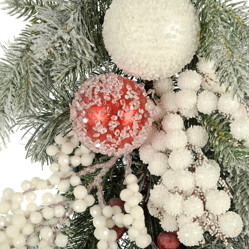 Christmas red and white baubles, white berries and green frosted pine garland