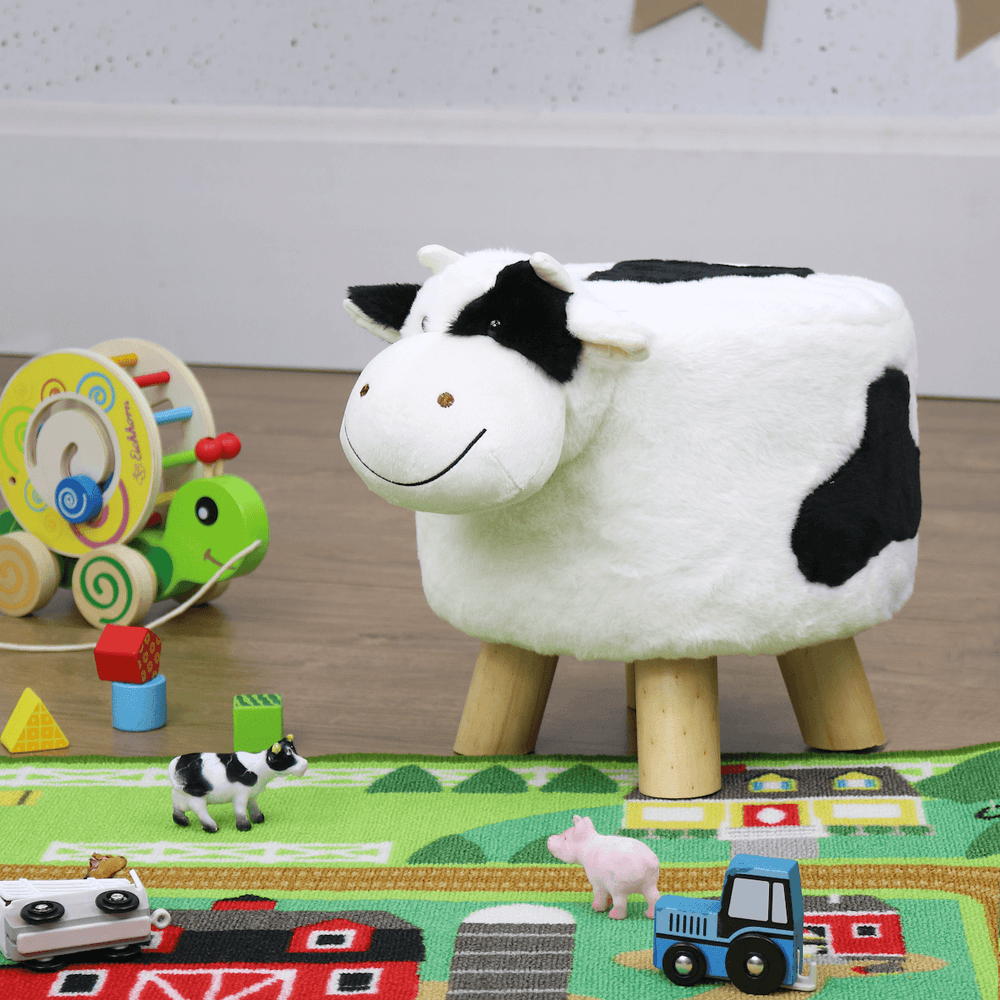 cow shaped kids stool in playroom with wooden toys to the side