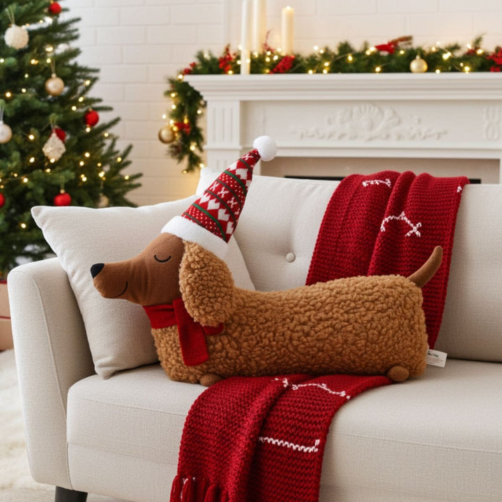 Decorative pillow shaped like a dog with a Santa hat on a couch in a festive living room.