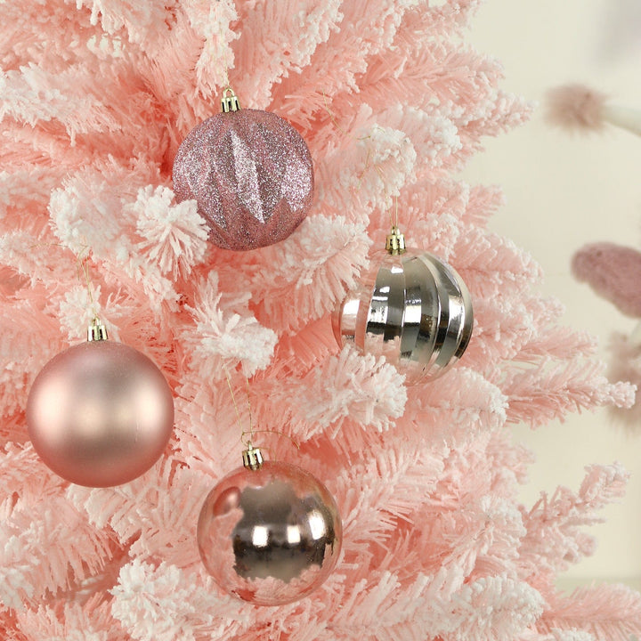 Decorative Christmas pink tree decorations on a pink and white tree.