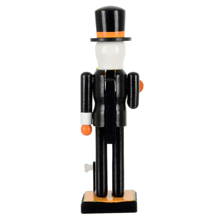 Wooden nutcracker figure with a black suit, white face, and top hat on a white background