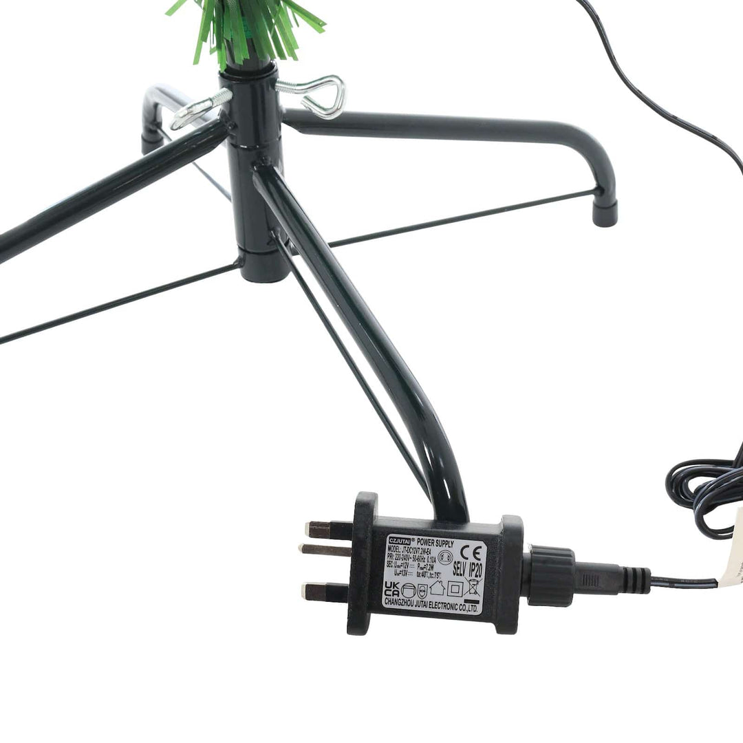 Black power adapter attached to a green string light fixture on a white background