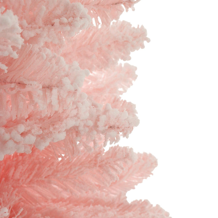 Close-up of a pink Christmas tree with flocked snow on a white background