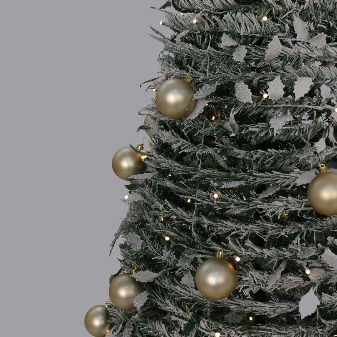 christmas tree on grey background with warm white led lights and gold christmas baubles