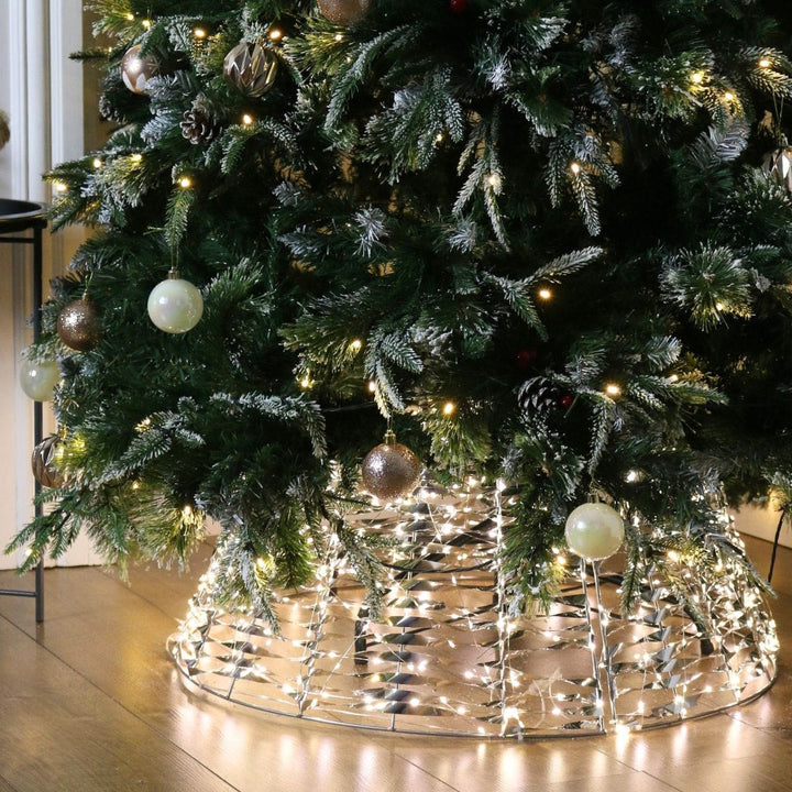 light up tree skirt on wooden floor with christmas tree inside featuring champagne colour baubles
