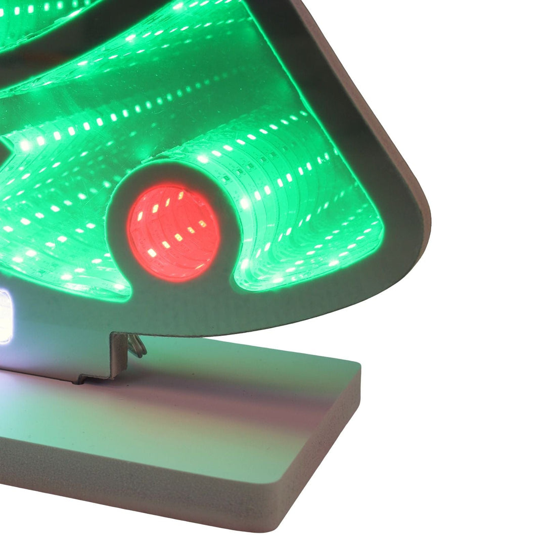 Close-up of a christmas tree infinity light with green and red lights on a white background