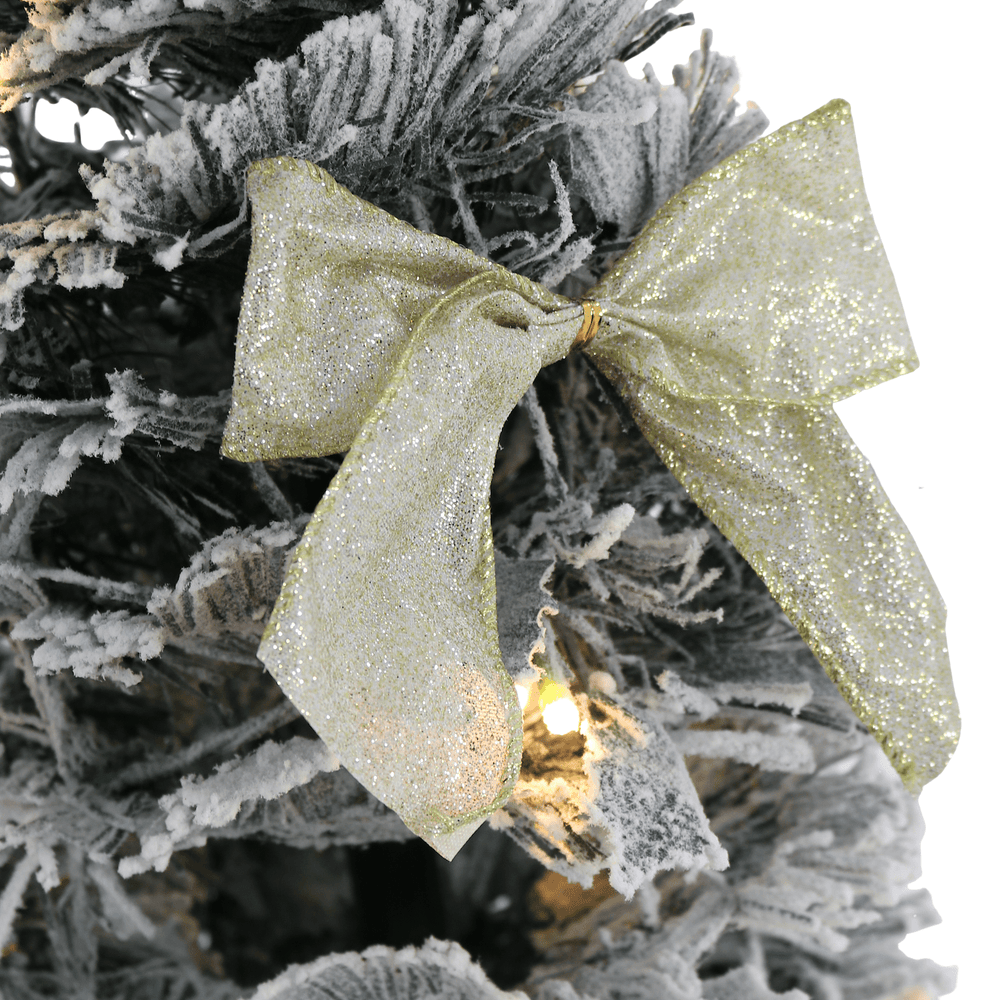gold glitter bow on flocked christmas tree
