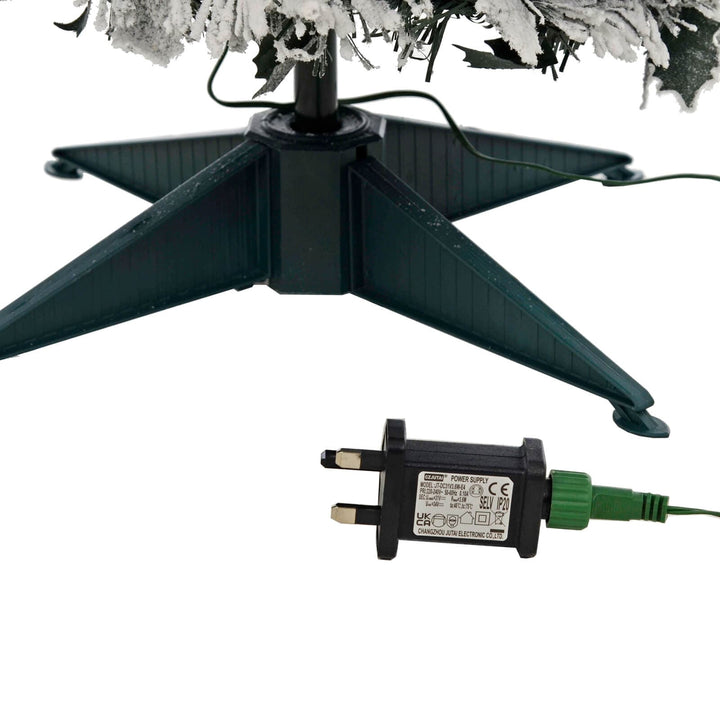 Christmas tree stand with electrical transformer plug on a white background