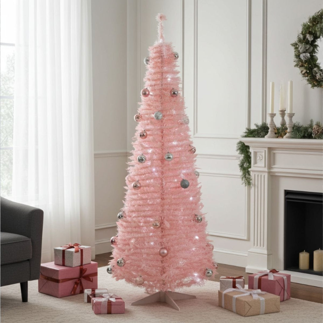 pink christmas tree in front of fireplace in living room with gifts on the floor