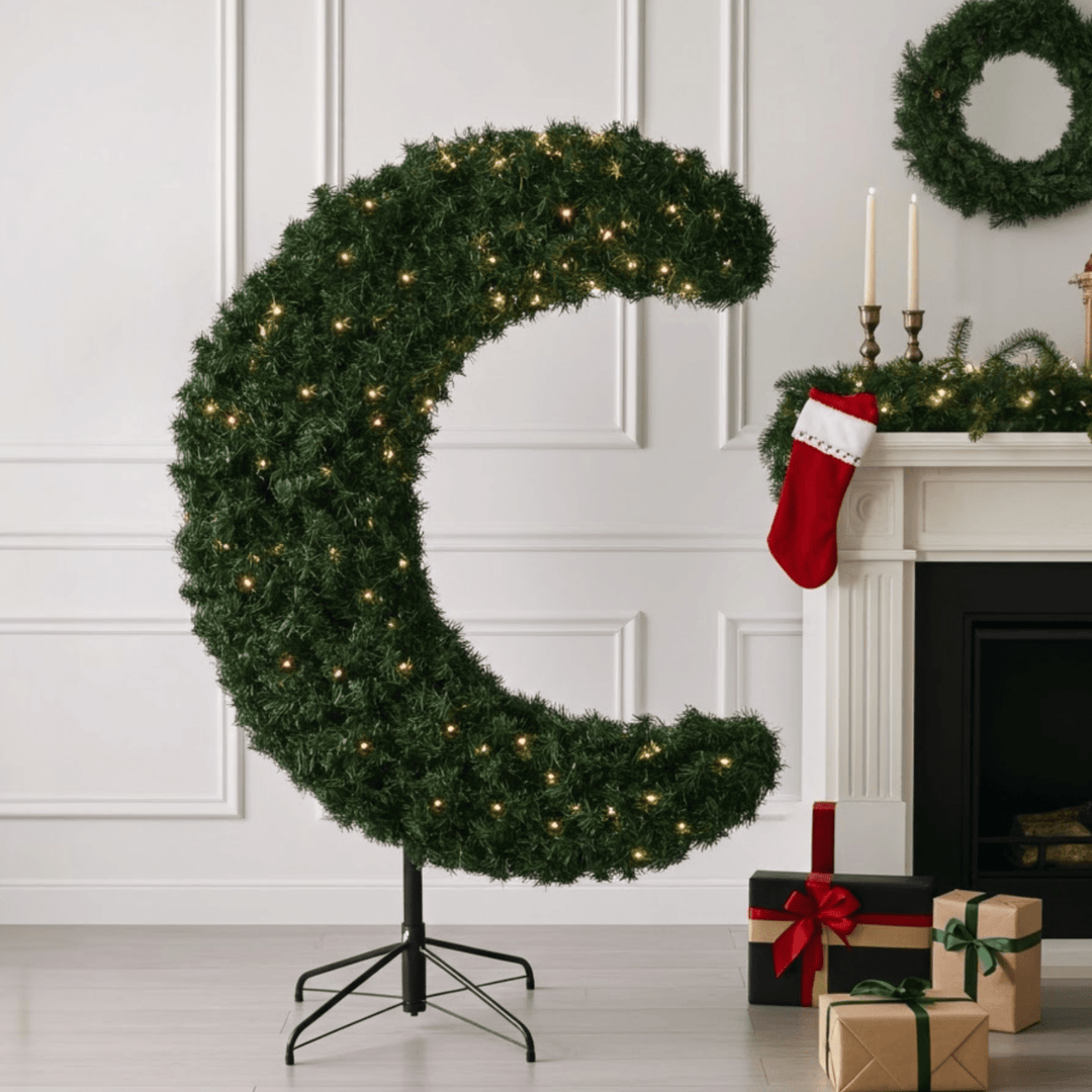 crescent moon shaped tree in contemporary room beside fireplace with gifts in front