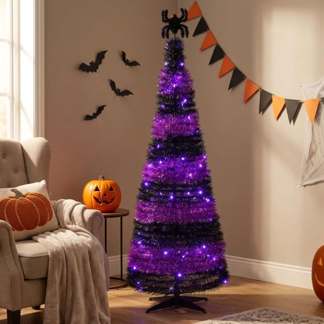 black and purple halloween tinsel tree in corner of room beside chair with pumpkin cushion and bunting in background