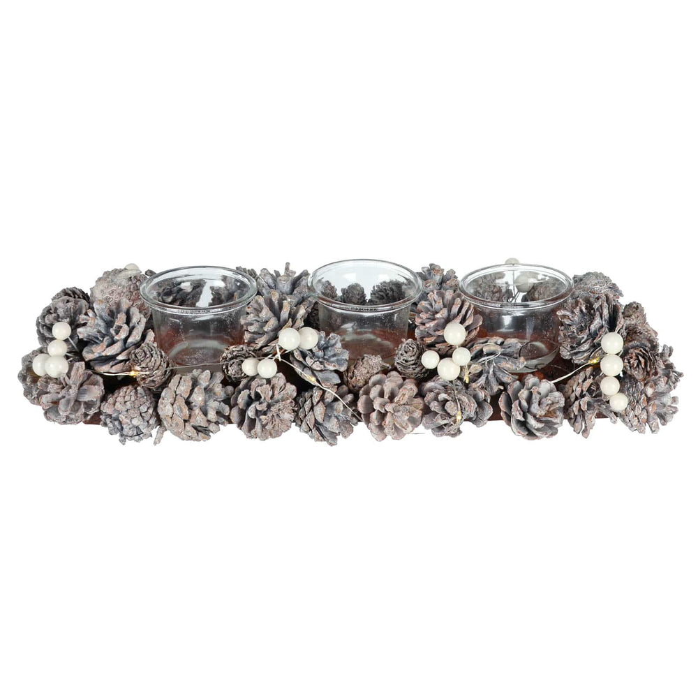 Decorative Christmas candle holder with pinecones and candles on a white background