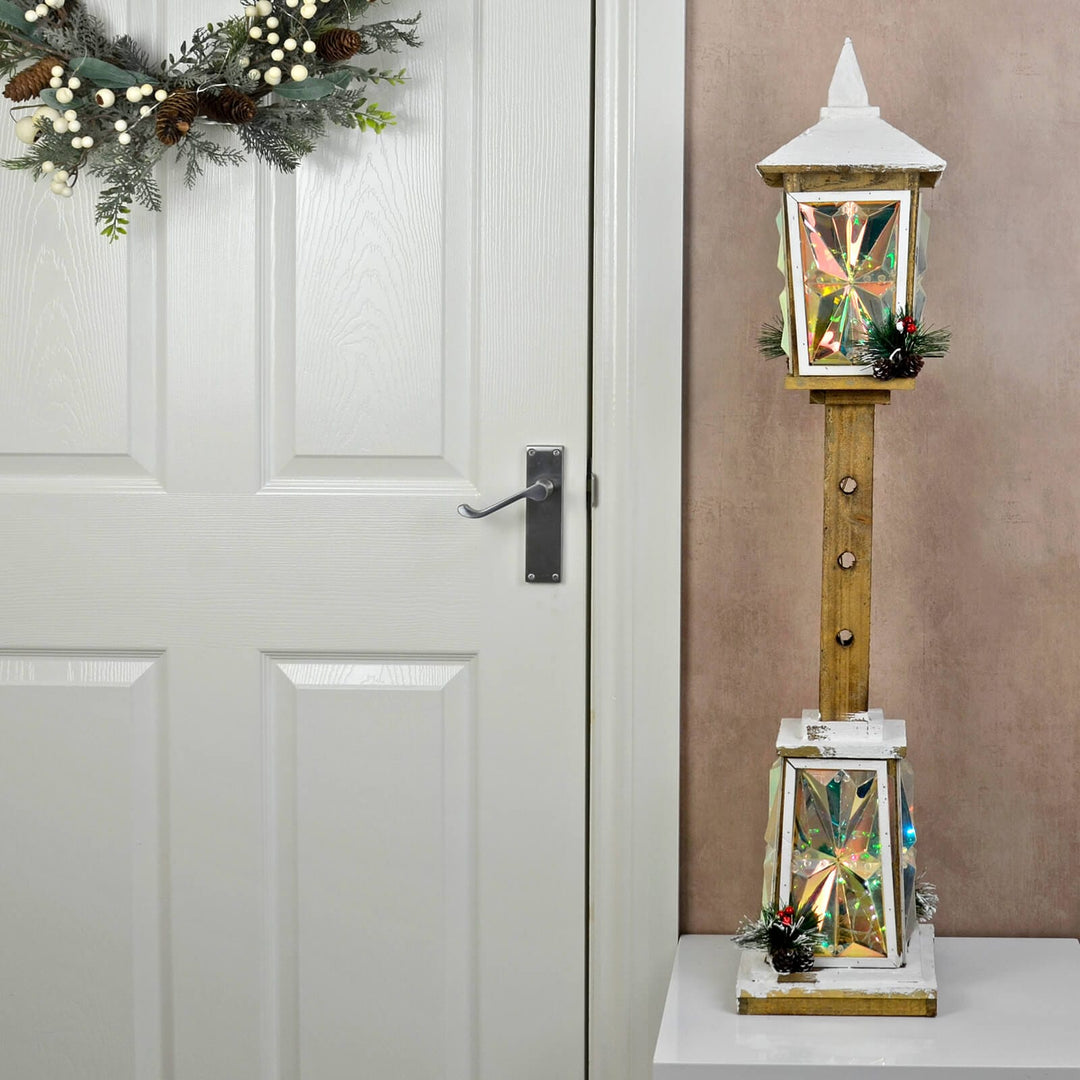 Decorative LD Christmas lantern with snow effect streetlight against a white door with a wreath.