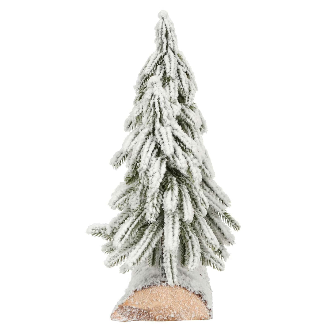 Side view of a snow flocked mini Christmas tree on a wooden log base