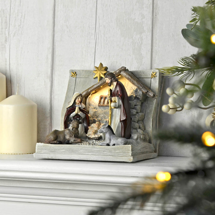 Light up Cristmas nativity scene on a mantelpiece with candle and fairy lights