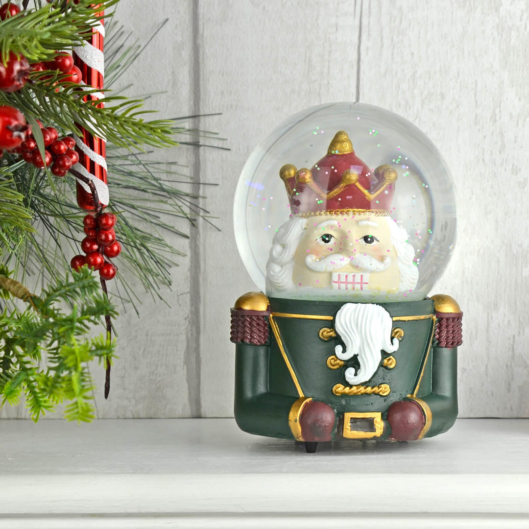 Christmas nutcracker soldier snow globe with trees and berries