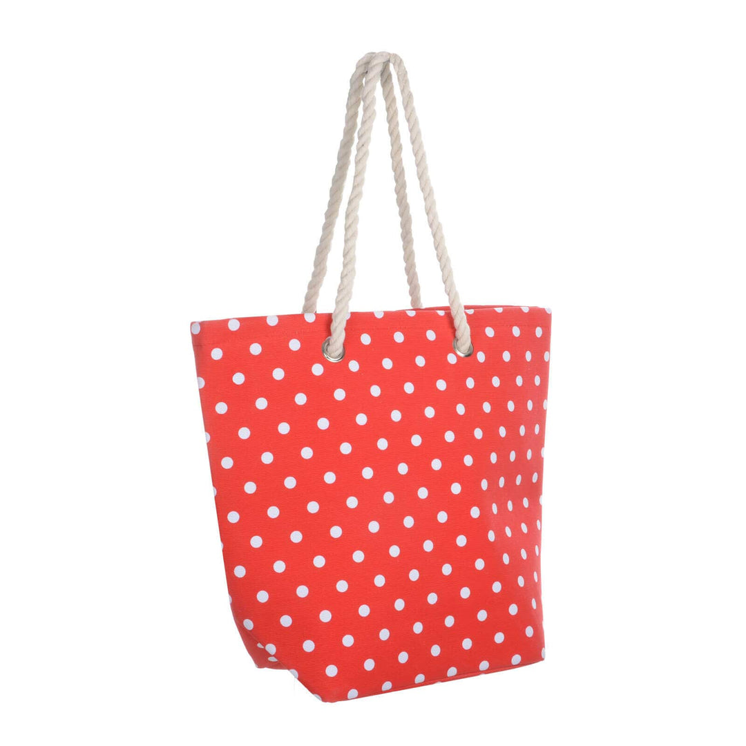Bright red beach bag with white polka dots and rope handles on a white background