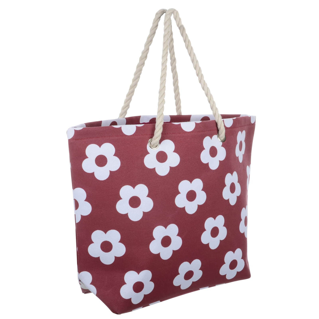 Dark red beach bag with white flowers and rope handles on a white background