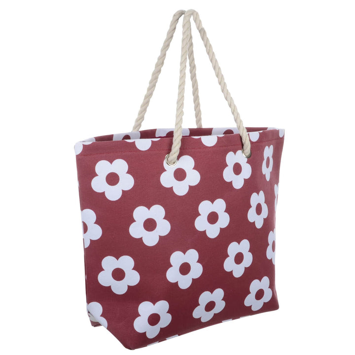 Dark red beach bag with white flowers and rope handles on a white background