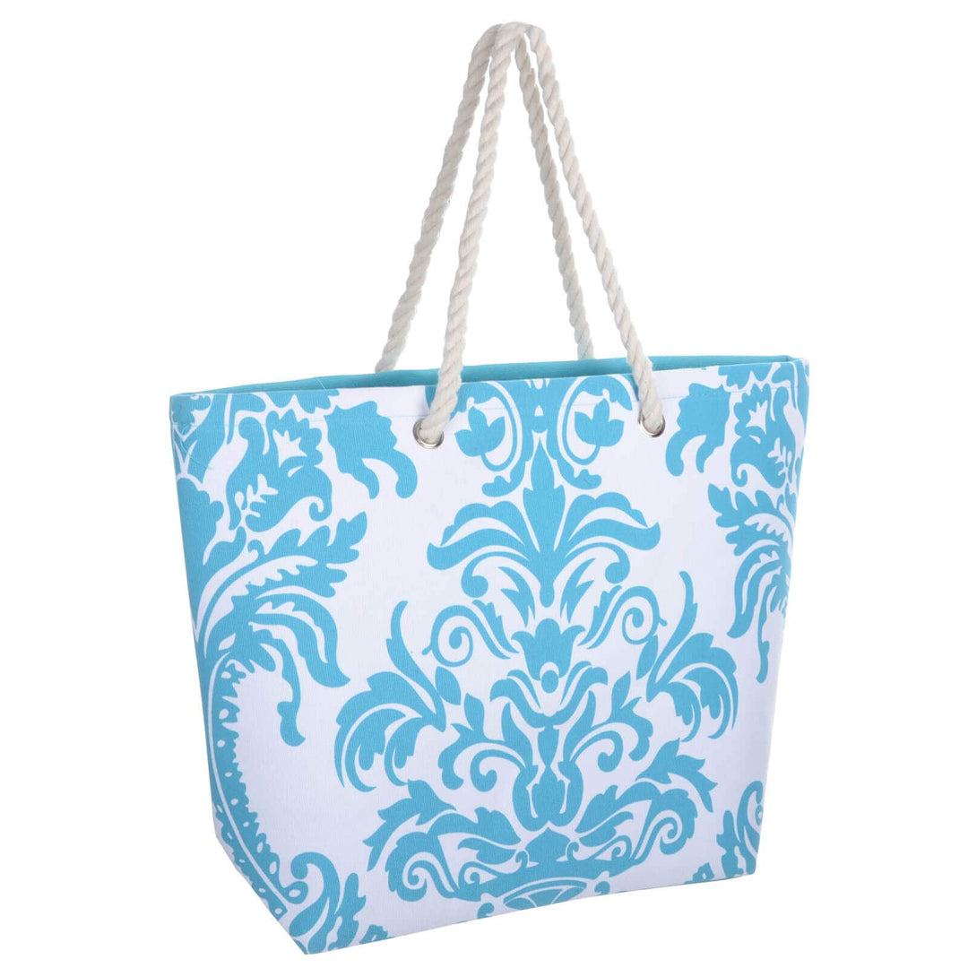 Bright blue floral beach bag with white rope handles on a white background